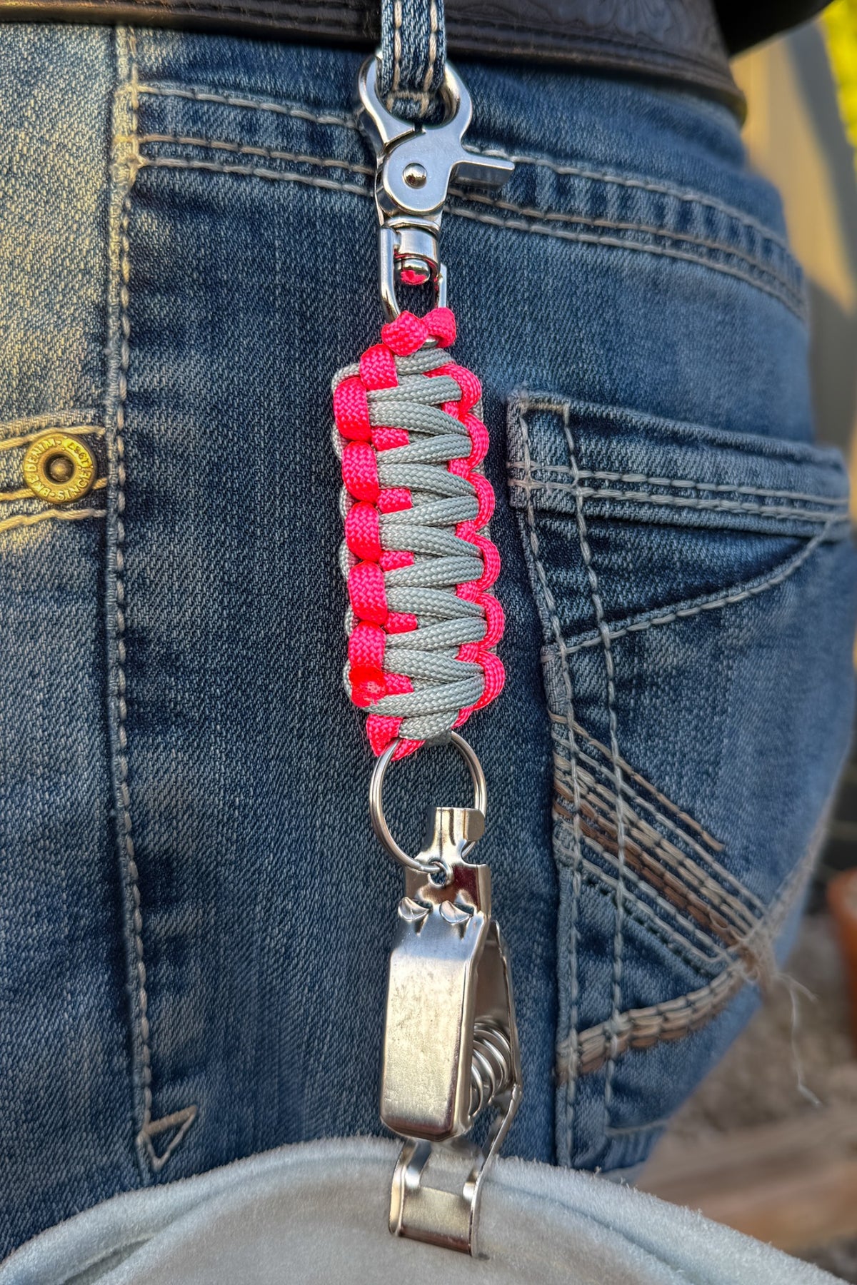 OLTX Pink Steel paracord glove clip in gray / hot pink attached to a belt loop