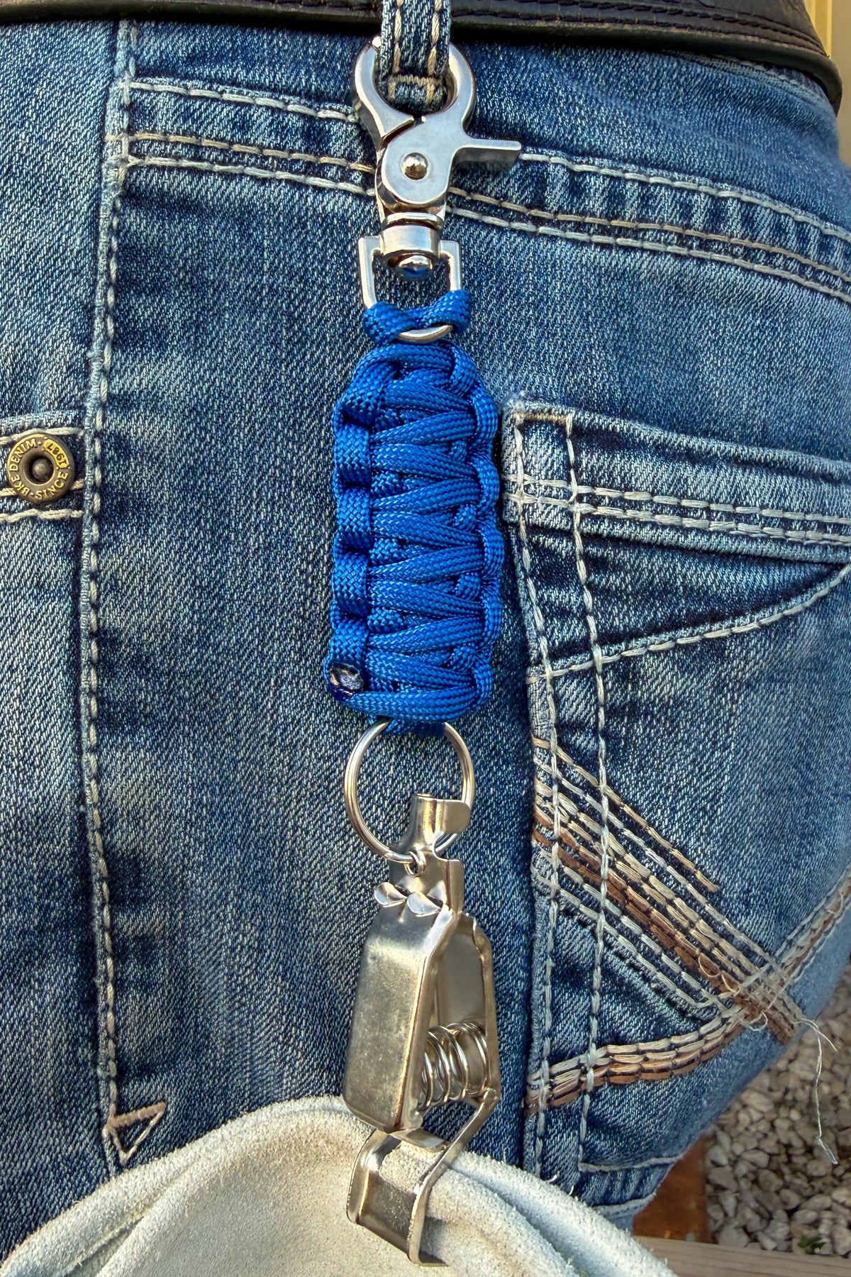 OLTX Arc Blue paracord glove clip in royal blue attached to a belt loop