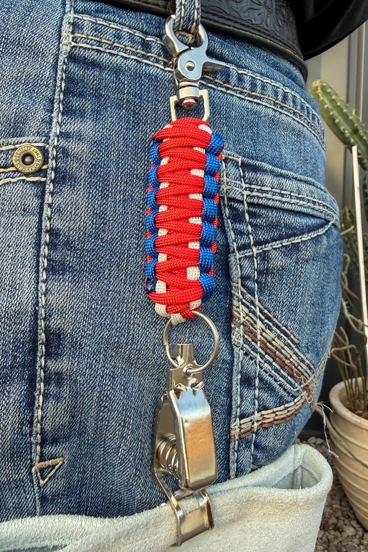 OLTX Patriot paracord glove clip in red / white / blue attached to a belt loop