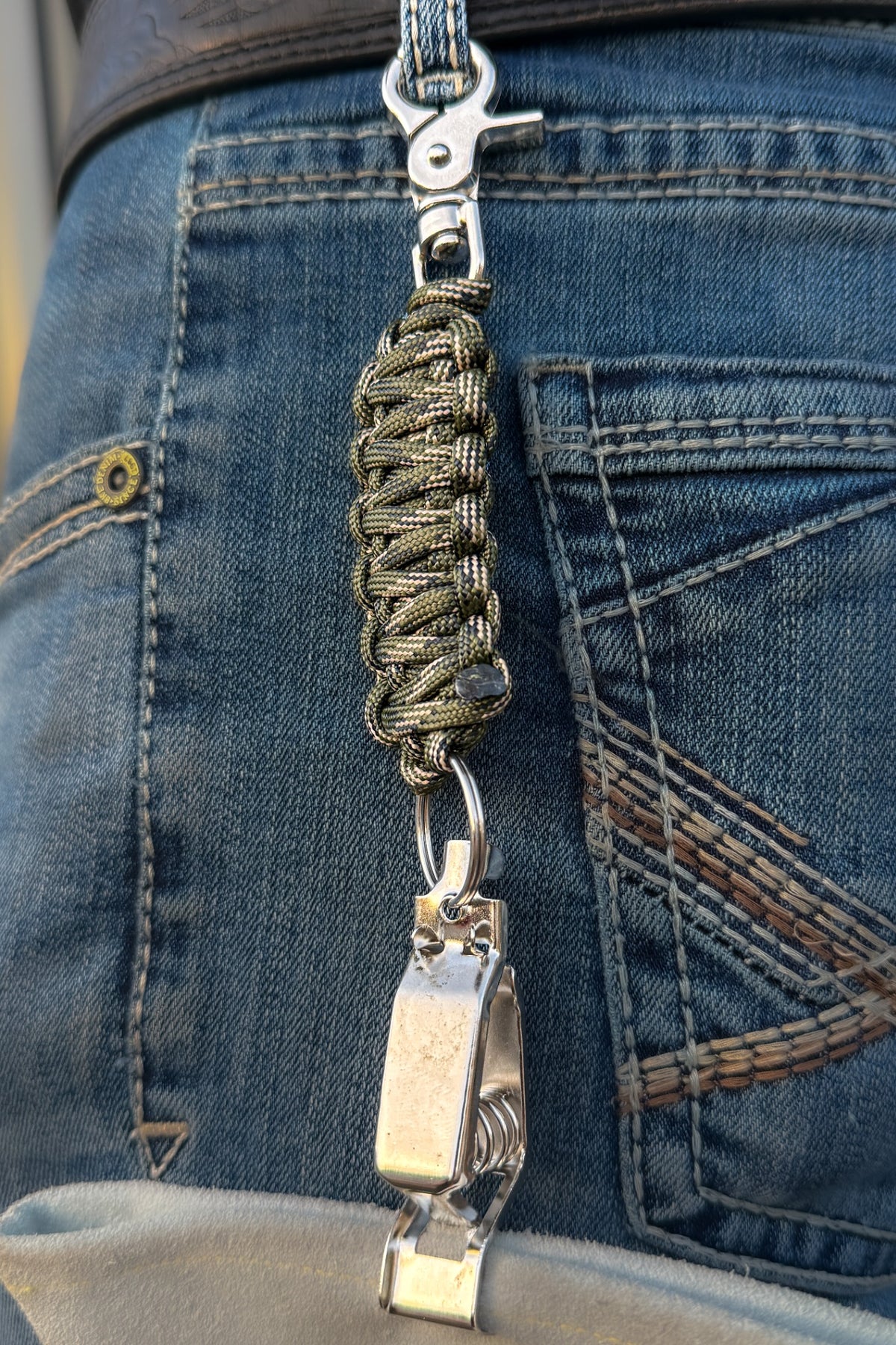 OLTX Rattler Camo paracord glove clip in olive / tan / black attached to a belt loop